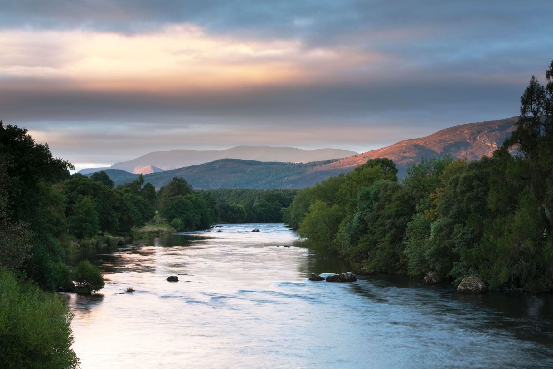 image of river as the sun is setting, scenic hills in the background